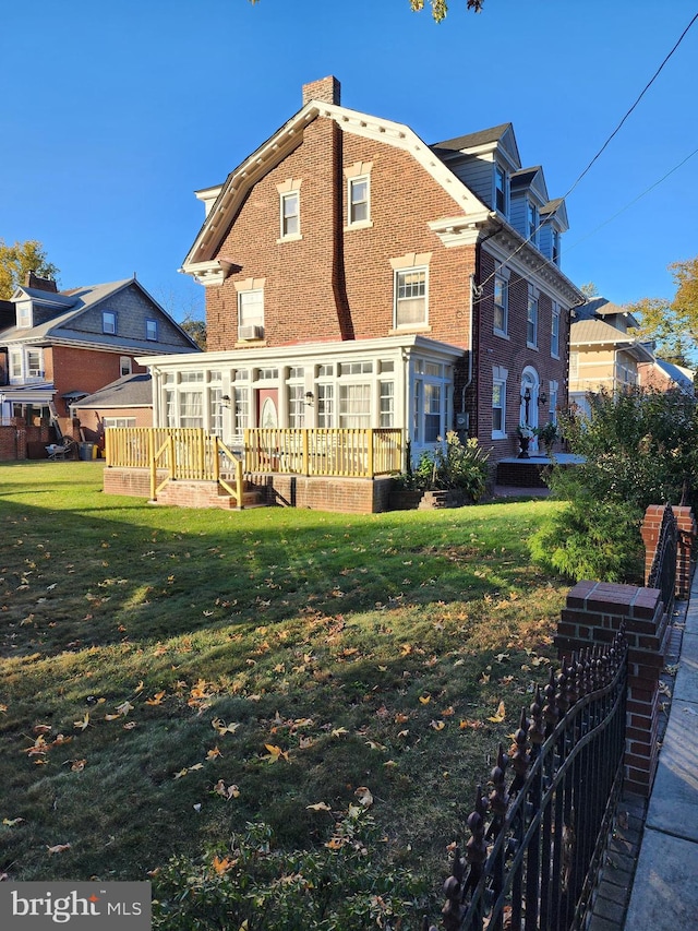 rear view of house with a wooden deck and a yard