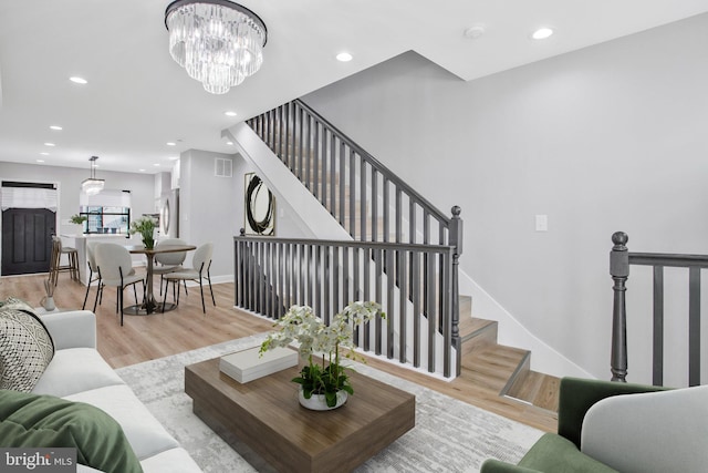 living room featuring light hardwood / wood-style flooring and an inviting chandelier