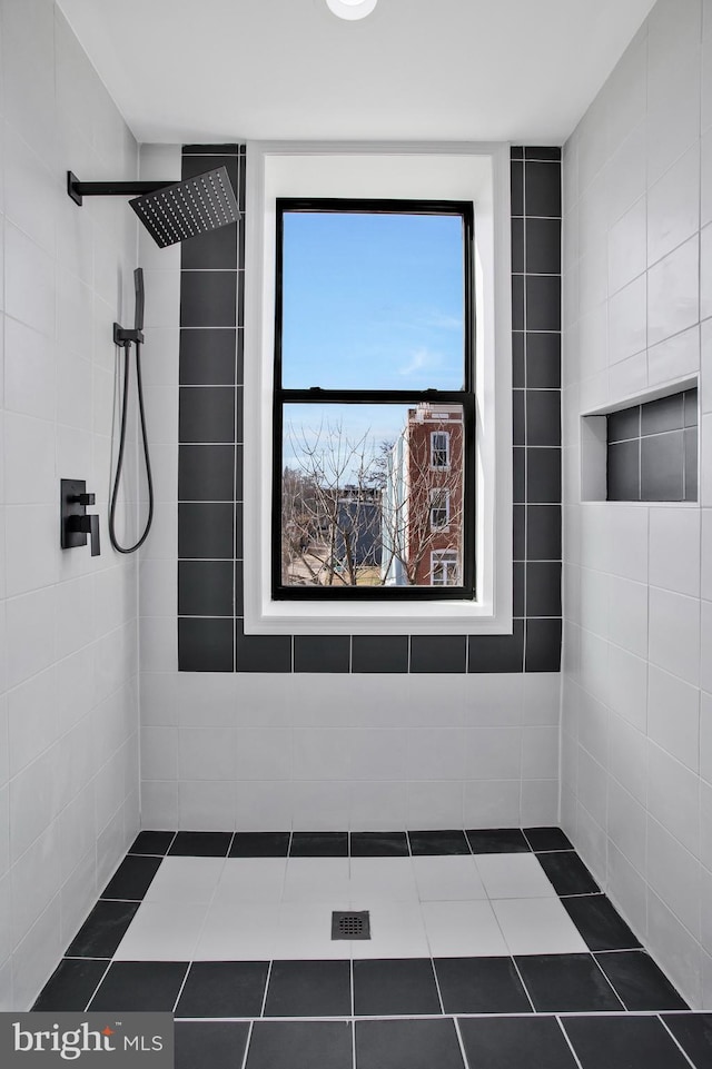 bathroom with a tile shower and a wealth of natural light