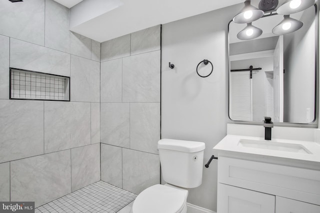 bathroom featuring tiled shower, vanity, and toilet