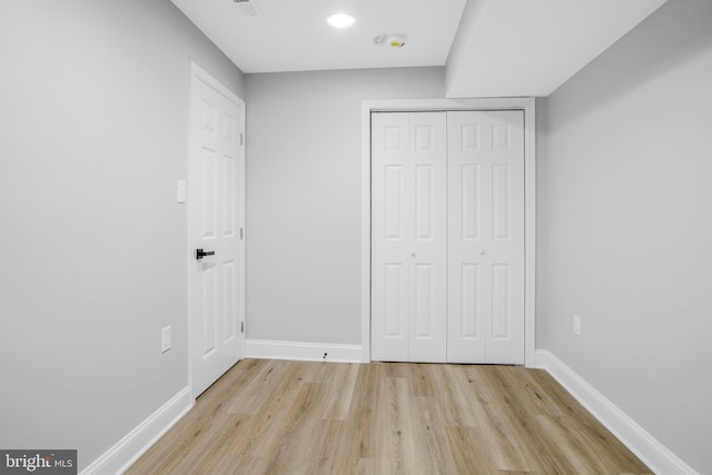 unfurnished bedroom with light hardwood / wood-style flooring and a closet