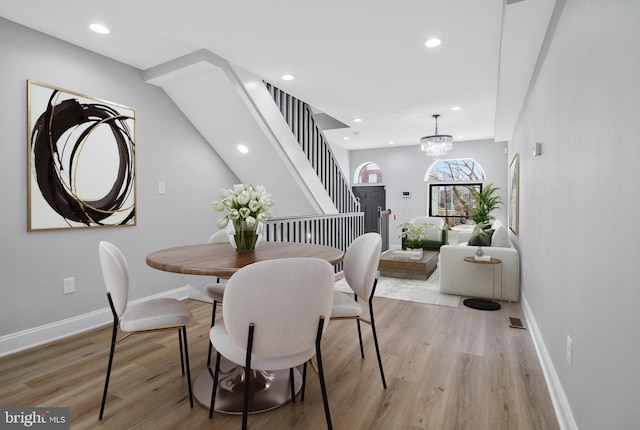 dining room with light hardwood / wood-style floors and an inviting chandelier