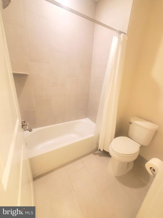 bathroom featuring tile patterned flooring, shower / bath combination with curtain, and toilet