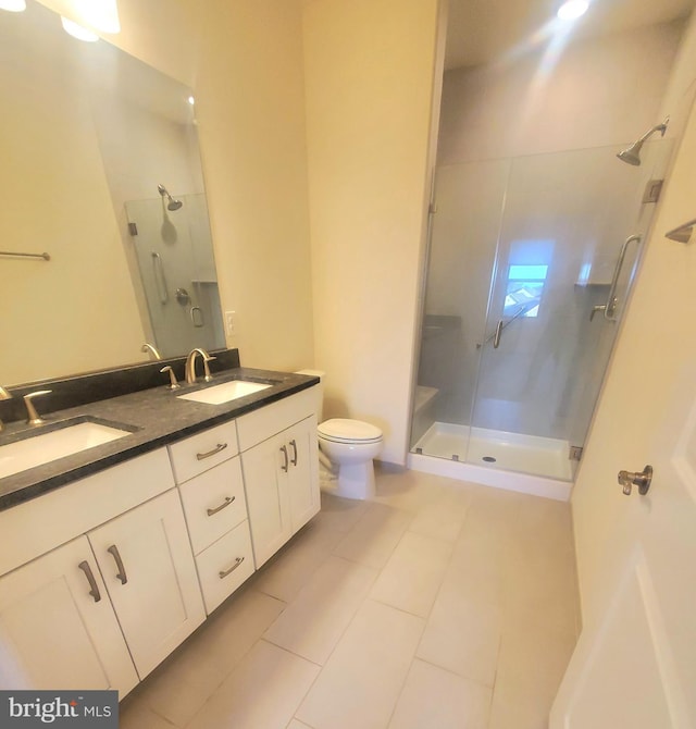 bathroom with tile patterned flooring, vanity, toilet, and a shower with shower door