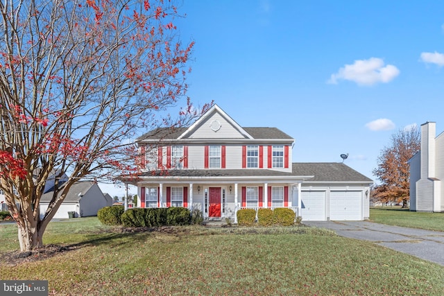 colonial inspired home with a front yard, a garage, and covered porch