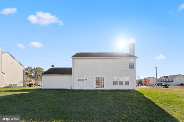 rear view of property with a lawn and central AC