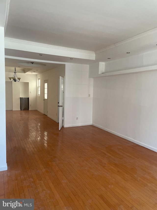 empty room with hardwood / wood-style flooring and an inviting chandelier