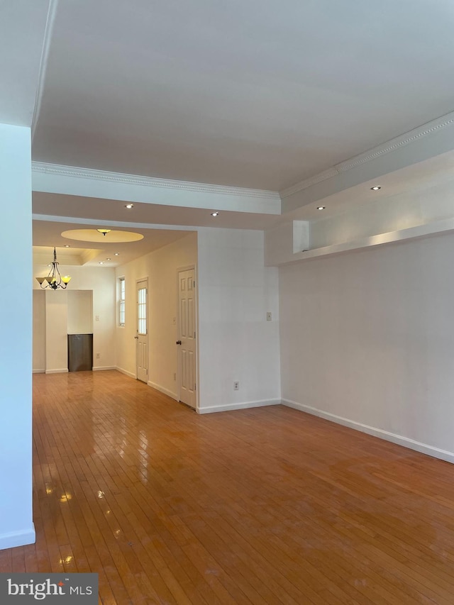 empty room with hardwood / wood-style flooring and ornamental molding