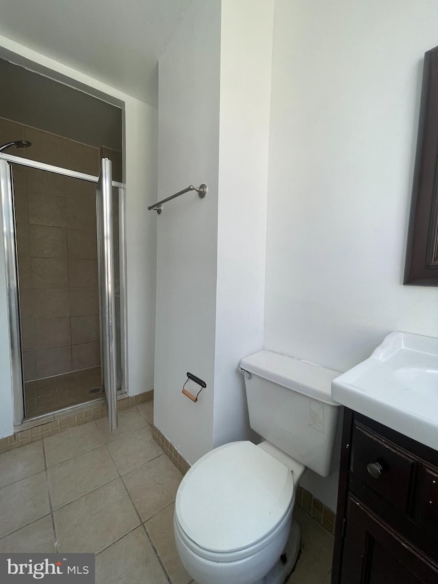 bathroom featuring vanity, toilet, walk in shower, and tile patterned flooring