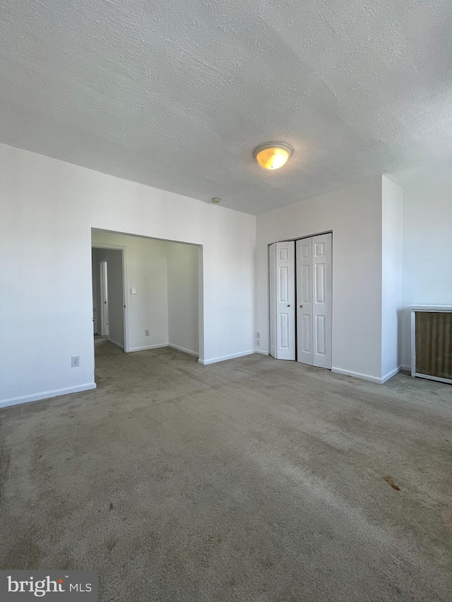 carpeted spare room with a textured ceiling