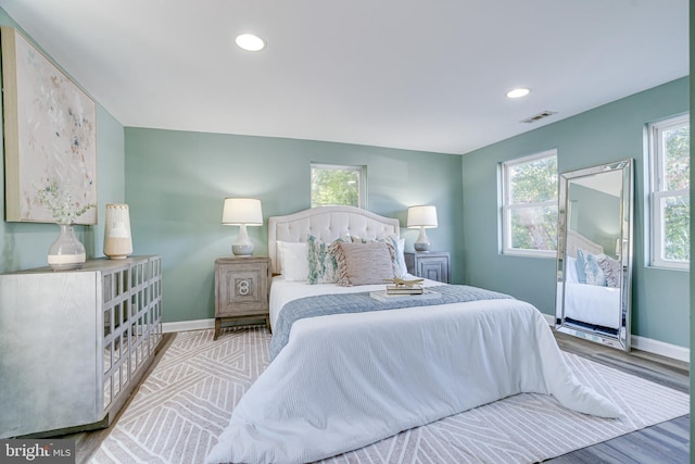 bedroom with light hardwood / wood-style floors and multiple windows