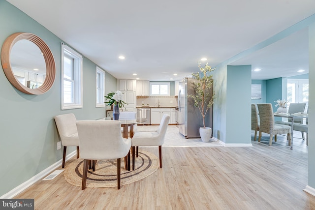 dining space featuring sink and light wood-type flooring