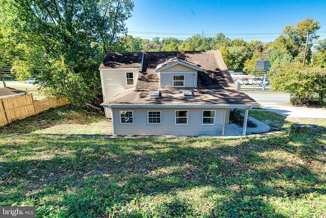 rear view of house featuring a lawn