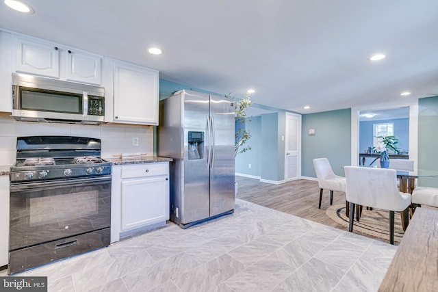 kitchen with stainless steel appliances, tasteful backsplash, light hardwood / wood-style flooring, and white cabinets