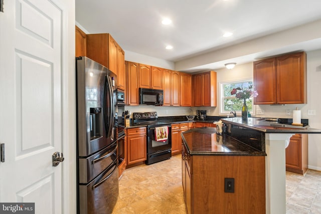 kitchen with a kitchen breakfast bar, a center island, black appliances, and dark stone counters