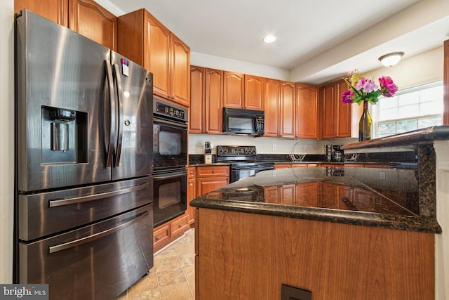 kitchen featuring dark stone countertops and black appliances