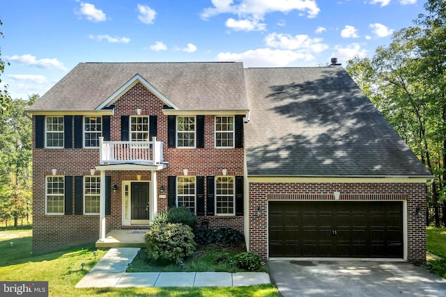 colonial home featuring a balcony, a garage, and a front lawn