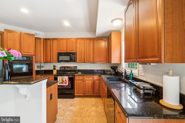 kitchen featuring sink, black appliances, and dark stone countertops