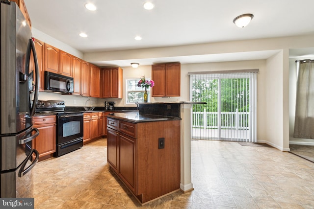 kitchen featuring dark stone countertops, black appliances, and a kitchen island