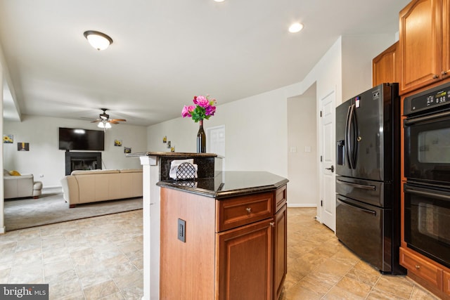 kitchen featuring black appliances, a kitchen island, and ceiling fan