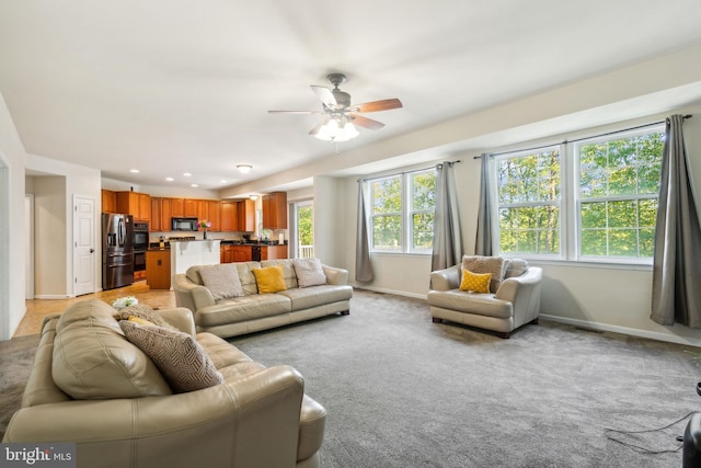 carpeted living room with ceiling fan