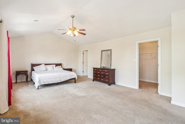 carpeted bedroom with a spacious closet, lofted ceiling, a closet, and ceiling fan