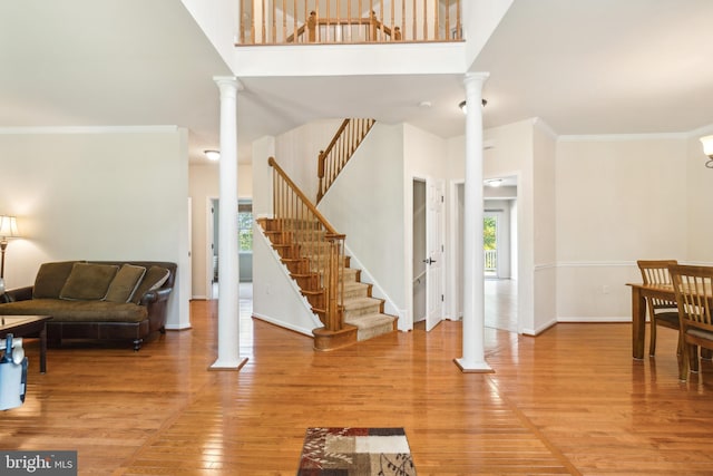 foyer entrance featuring ornamental molding, a high ceiling, and hardwood / wood-style flooring