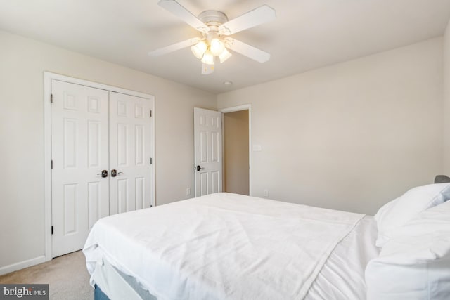 bedroom with a closet, light colored carpet, and ceiling fan