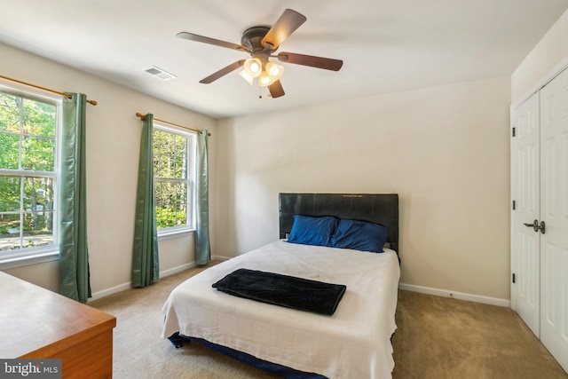 carpeted bedroom featuring a closet and ceiling fan