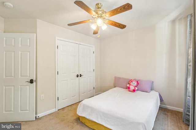 bedroom with a closet, ceiling fan, and light colored carpet