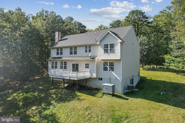 back of property with central AC and a yard