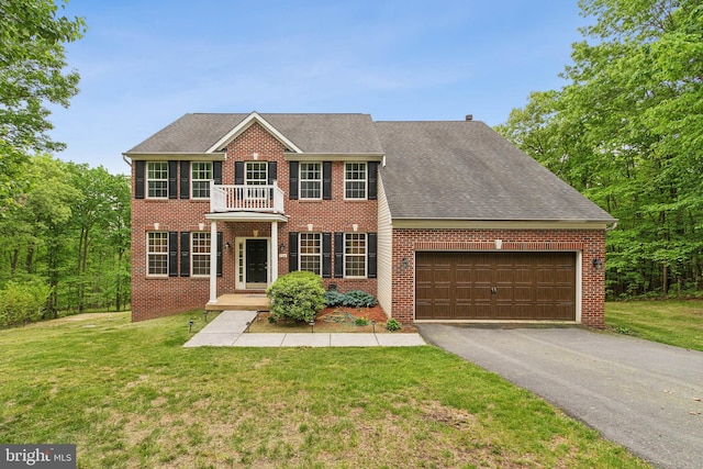 colonial home with a front yard, a balcony, and a garage