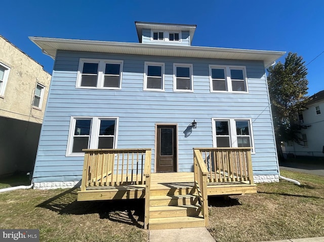 view of front of house featuring a front yard and a wooden deck