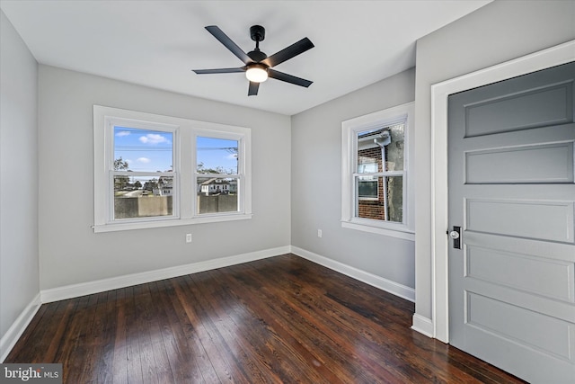 spare room with dark wood-type flooring and ceiling fan