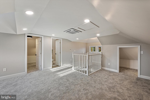 additional living space with light carpet and vaulted ceiling