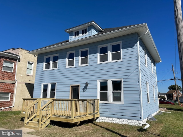 rear view of property featuring a wooden deck and a yard