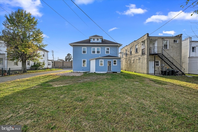 rear view of house featuring a lawn