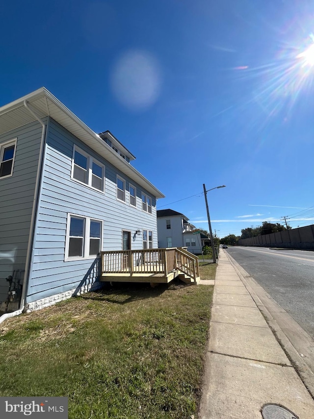 back of property featuring a yard and a deck