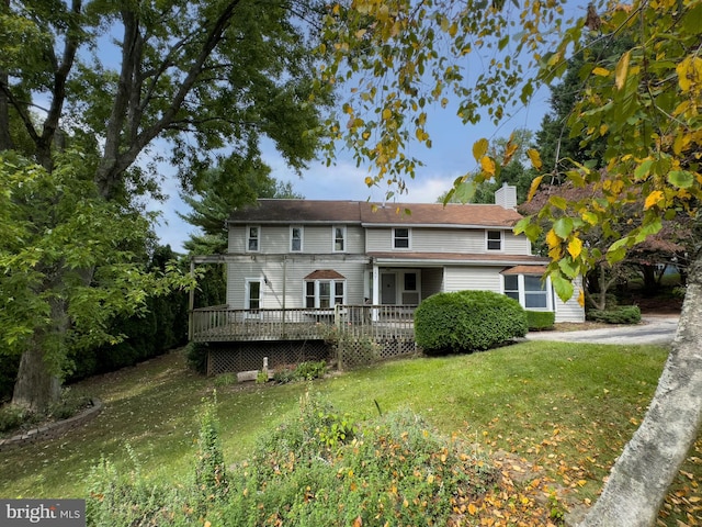 view of front of property with a wooden deck and a front lawn