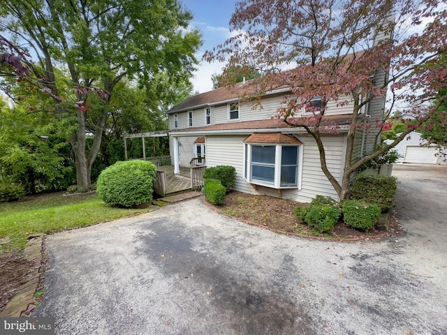 view of front of home with a deck, an outbuilding, and a garage