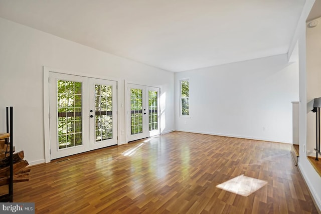 unfurnished living room with french doors, wood-type flooring, and plenty of natural light