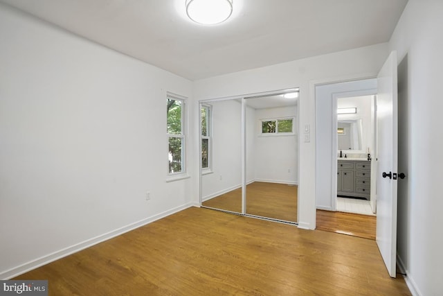 unfurnished bedroom featuring a closet and light wood-type flooring