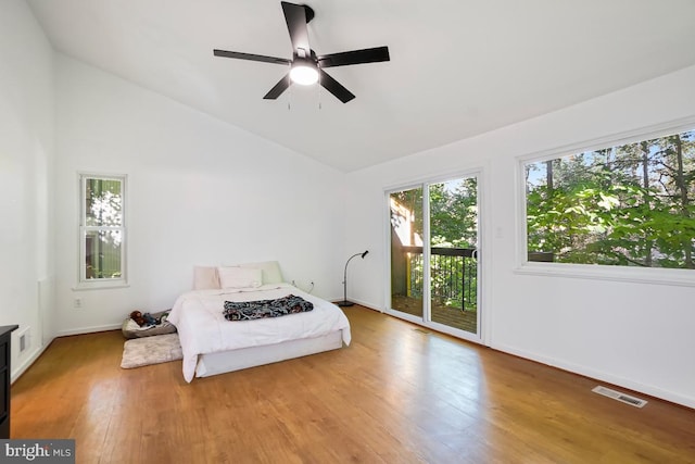 bedroom with ceiling fan, high vaulted ceiling, access to outside, and hardwood / wood-style floors