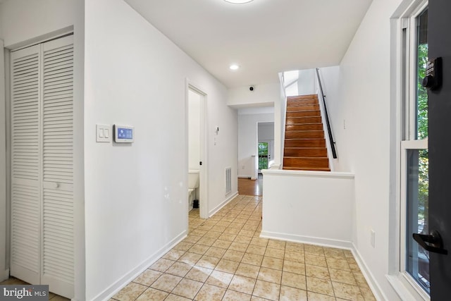 hall with light tile patterned floors