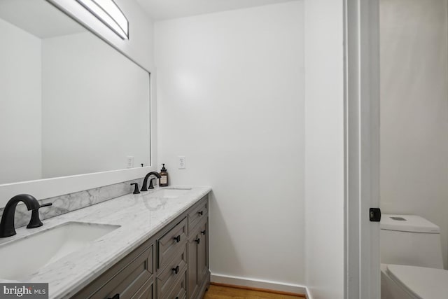 bathroom featuring vanity, hardwood / wood-style floors, and toilet