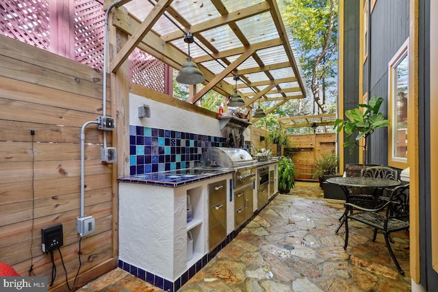 view of patio / terrace with a pergola, ceiling fan, exterior kitchen, and a grill