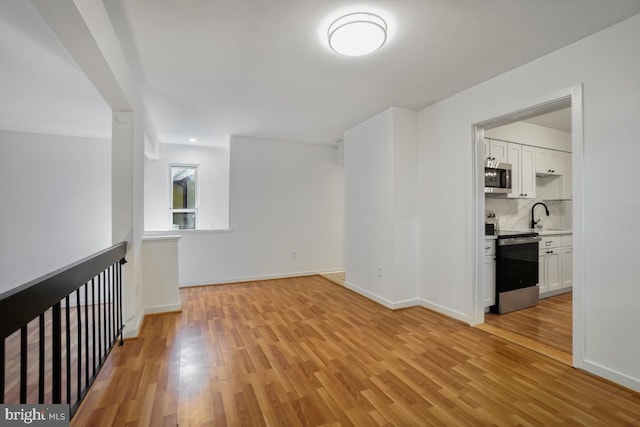 empty room with sink and light wood-type flooring