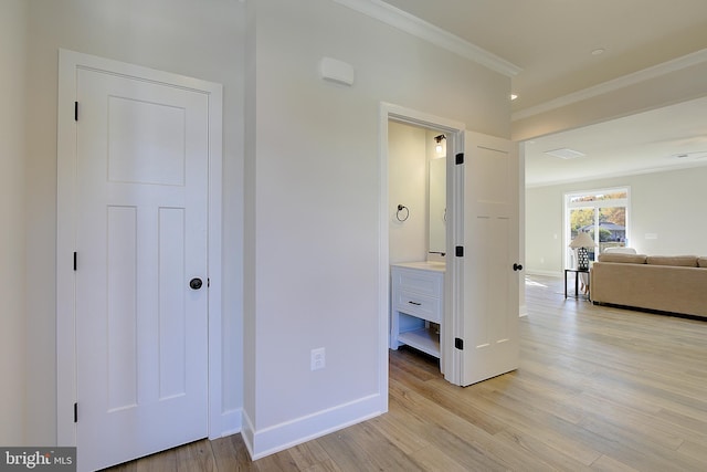 corridor with crown molding and light hardwood / wood-style flooring