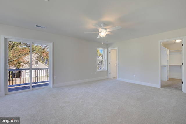 carpeted empty room featuring plenty of natural light and ceiling fan