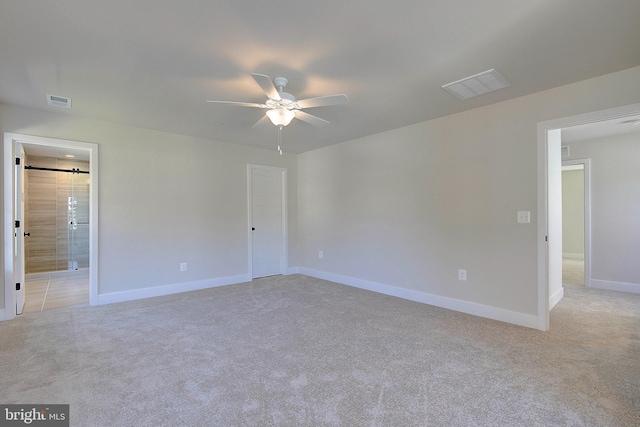 unfurnished room with ceiling fan and light carpet